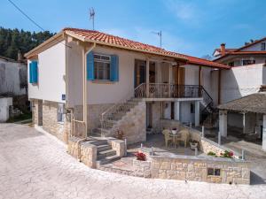 a small house with a staircase in a street at Patriko Stone House in Fourka