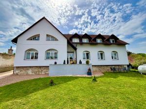 Pernštejnské JestřabíApartmány Maňová的一座带草地庭院的大型白色房屋