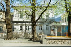 a white building with trees in front of it at Apartment Bambola in Ajdovščina