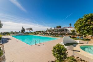 a swimming pool in the middle of a resort at Vilas Marrocha in Porches