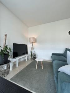 a living room with a blue couch and a tv at Free Parking - Near the Lake - Lugano apartment in Paradiso