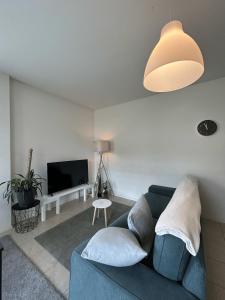 a living room with a blue couch and a lamp at Free Parking - Near the Lake - Lugano apartment in Paradiso
