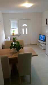 kuchnia i jadalnia z drewnianym stołem i krzesłami w obiekcie Apartment Petra w mieście Starigrad-Paklenica