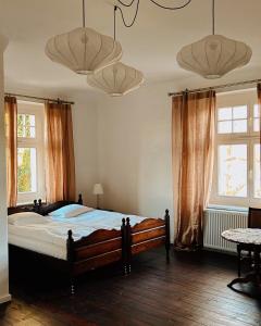 ein Schlafzimmer mit einem großen Bett und zwei Fenstern in der Unterkunft Pałac Pozorty in Pozorty