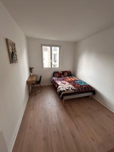 a bedroom with a bed and a desk in it at Studio cosy proche transports in Aulnay-sous-Bois
