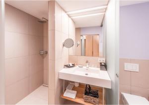 un bagno con un lavandino bianco e una doccia di Göttfried - essen trinken schlafen a Linz