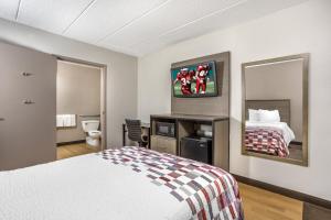 a hotel room with a bed and a mirror at Red Roof Inn Tinton Falls-Jersey Shore in Tinton Falls +25 photos