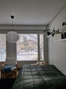 a bedroom with a bed and a large window at Cozy one-bedroom apartment with sauna in Rauma