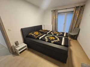 a bedroom with a black bed with a window at Apartment Rückertstraße in Nordhausen +7 photos