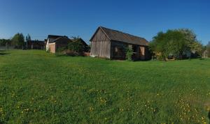 an old barn in a field of green grass at Siedlisko Magnolia in Wólka Sulejowska