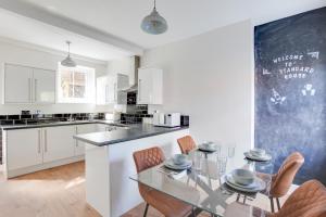 a kitchen with a glass table and chairs and a chalkboard at Cosy 3 bedroom house with Free parking and WiFi in Colchester
