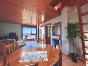 a living room with a wooden table and a dining room at ROOMS El Descanso del Peregrino por la Costa in Oia