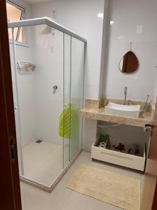a bathroom with a glass shower and a sink at Apartamento Carla in Domingos Martins