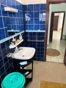 a bathroom with a sink and a blue tiled wall at Résidence avec gardien en plein centre de Bonapriso proche aéroport in Douala +21 photos