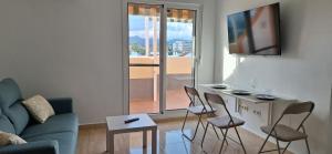 a living room with a couch and chairs and a tv at A & G Sabinillas in San Luis de Sabinillas