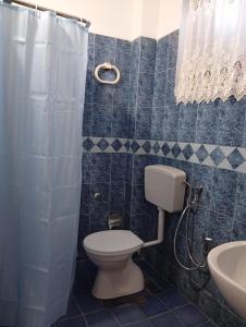 a blue tiled bathroom with a toilet and a sink at Arta room in Durrës