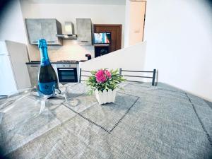 una botella de vino y una flor en una mesa en Appartamenti Abbaidda, en Valledoria 107 fotos más