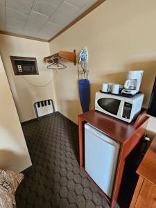 a room with a microwave on a table at Forest Plaza Motel in Mount Forest