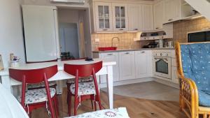 a kitchen with white cabinets and red stools in it at Cosy Nest in Bovec