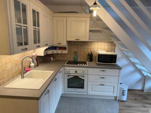 a kitchen with white cabinets and a sink at Cosy Nest in Bovec