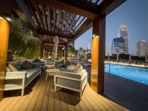 a patio with couches and a pool with a city skyline at The Address Residences Dubai Opera - Luxury 3BR Stay with Stunning Burj Khalifa & Fountain Views in Dubai