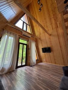 an attic room with a large window and wooden ceilings at Lerik kirayə ev in Lerik