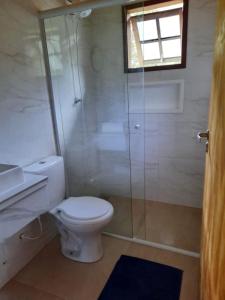 a bathroom with a shower and a toilet and a sink at Sítio Jabuticabeira in Santo Antônio do Pinhal