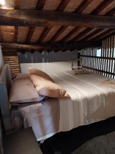 een groot wit bed met kussens in een kamer bij Casa San Rocco in Pitigliano