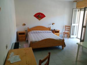 1 dormitorio con 1 cama, mesa y sillas en Hotel Panorama, en Badesi