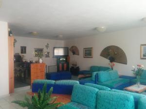 a living room with blue couches and a television at Hotel Panorama in Badesi