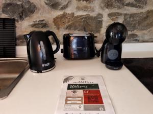 a tea kettle and a toaster sitting on a counter at Social Lodge Galinho in Estreito da Calheta