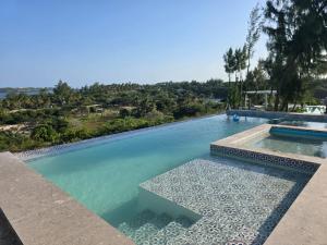 a swimming pool with a view of the water at Dzixile in Gueima