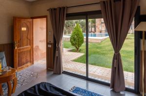an open door to a patio with a view of a yard at Atlas Front in Marrakech