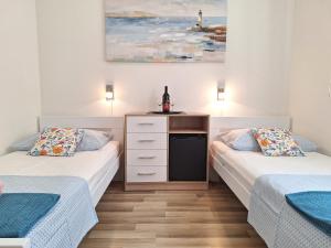 a bedroom with two beds and a dresser in it at Apartments Villa Sirena in Dubrovnik