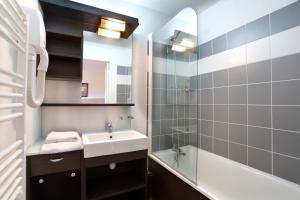 a bathroom with a sink and a tub and a mirror at Vacancéole - Les Chalets du Verdon in La Foux +18 photos