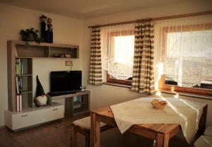 a living room with a table and a tv at Lü de Terza in San Vigilio Di Marebbe
