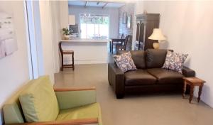 a living room with a couch and a kitchen at 177 on Church in Oudtshoorn