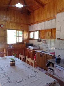 a kitchen with wooden cabinets and a table in a room at Casa de la Guayubira in El Soberbio