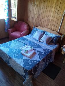 a bedroom with a bed with a blue blanket and a chair at Casa de la Guayubira in El Soberbio +40 photos
