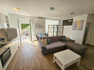 a living room with a couch and a table at Apartments Majic Zivogosce in Živogošće