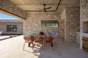a stone walled kitchen with a table and chairs at NEW! Contemporary Villa Fantazija – A Luxurious Retreat in Dicmo in Dicmo