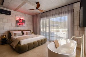 a bedroom with a bed and a tub and a window at NEW! Contemporary Villa Fantazija – A Luxurious Retreat in Dicmo in Dicmo +47 photos