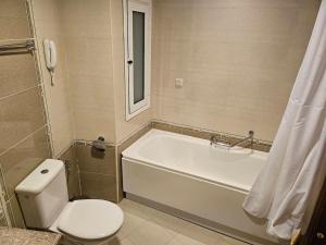 a bathroom with a tub and a toilet and a sink at Luxury apartment in Downtown Resort Bansko in Bansko +16 photos