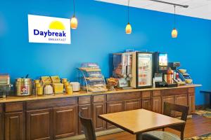 una barra de restaurante con una mesa y una pared azul en Days Inn by Wyndham Southington, en Southington