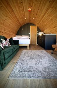 a living room with a green couch and a bed at Ballyhoura Glamping in Ballyorgan +20 photos