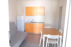 a kitchen with a table and chairs and a refrigerator at Case al mare in Salento - bilocale B7 in Marina di Leuca