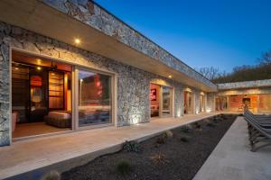 a house with a stone wall and a patio at NEW! Contemporary Villa Fantazija – A Luxurious Retreat in Dicmo in Dicmo