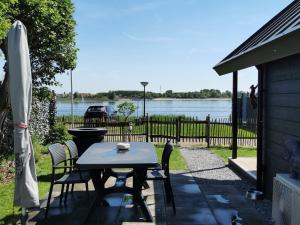 LathumTiny Haus Auszeit am See的享有水景的天井配有桌椅