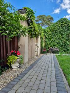a stone walkway in front of a building with flowers at New two bedroomJurmala apartment in Jūrmala
