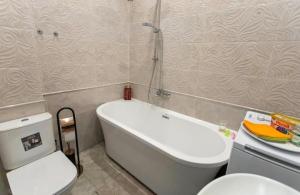 a bathroom with a tub and a toilet and a sink at New two bedroomJurmala apartment in Jūrmala +10 photos